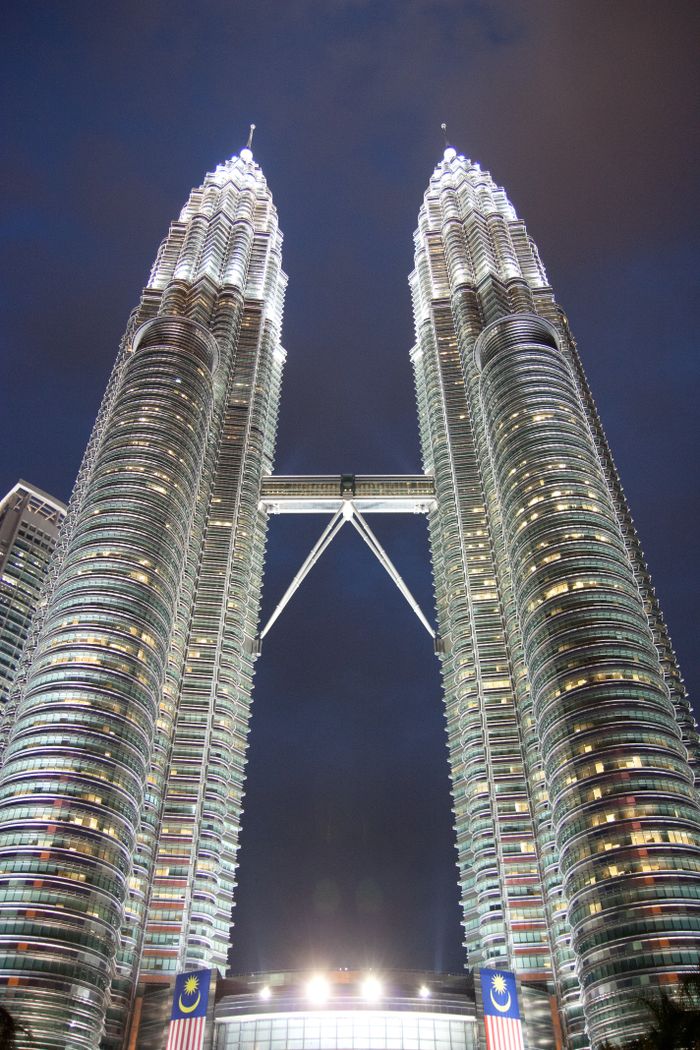 The iconic Petronas Twin Towers illuminated against the twilight sky in Kuala Lumpur.